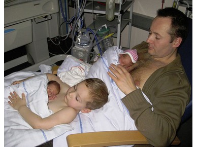 Баща и син "кожа до кожа" с новородени близнаци